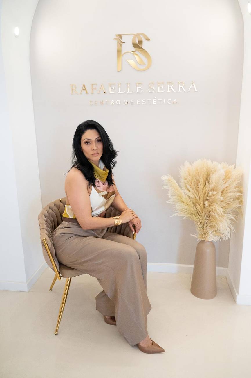 Rafaelle Serra no centro de estética em Albufeira, sentada sob o logótipo dourado da clínica